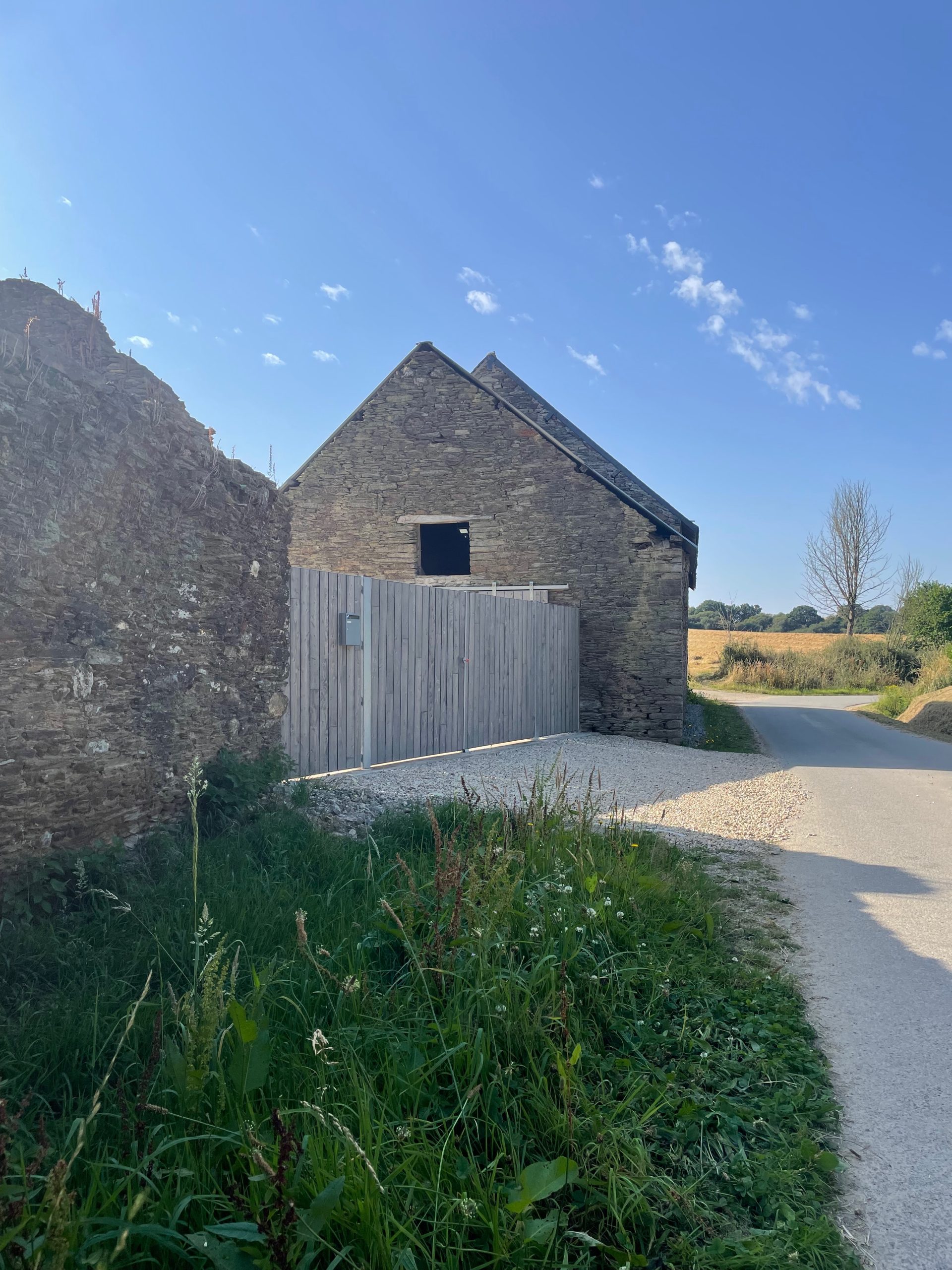 External view of entrance with cypress clad gate matching the sliding shutters of the house and guest accommodation
